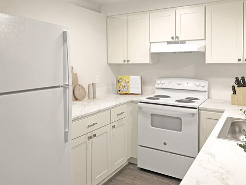 a kitchen with white appliances and white cabinets